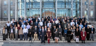 Group image of DNFSB employees and contractors standing on steps in front of a building