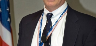 Image of a man wearing a blue tie and speaking at the 2010 Victor Stello Junior award presentation